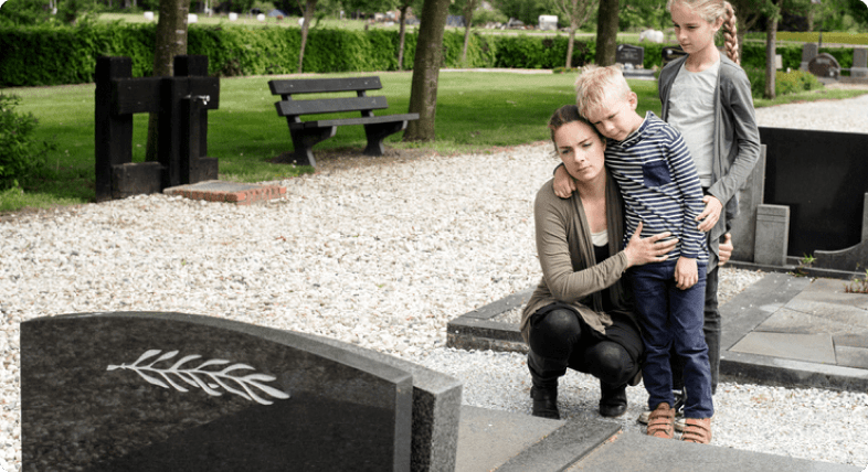A woman and a child standing next to a gravestone in search of personal injury guidance.