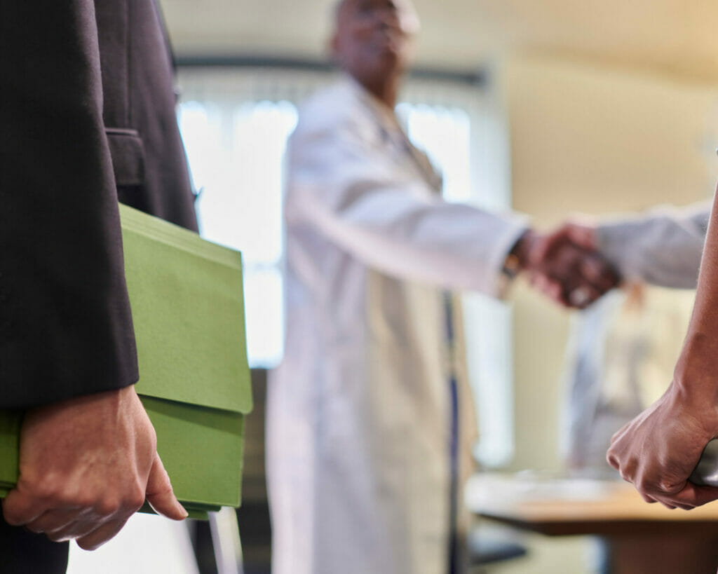 A group of people shaking hands in a doctor's office.